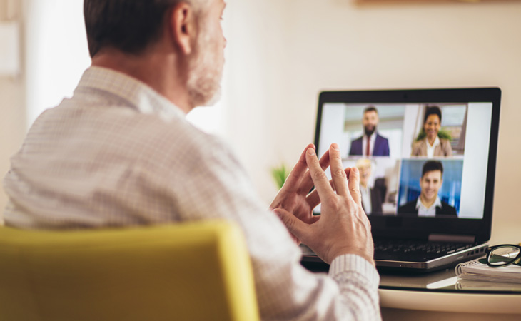 Man sitting at a desk, participating in a video chat meeting