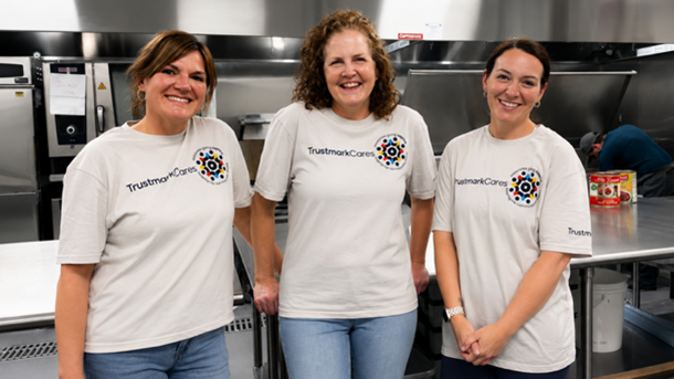 Three smiling Trustmark employees volunteering at Gather.