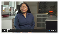 Video still image of a woman in her house