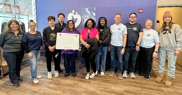 Group of employees holding a sign at Keeping America Covered.