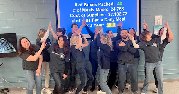 Excited employees high-fiving at Feed My Starving Children.